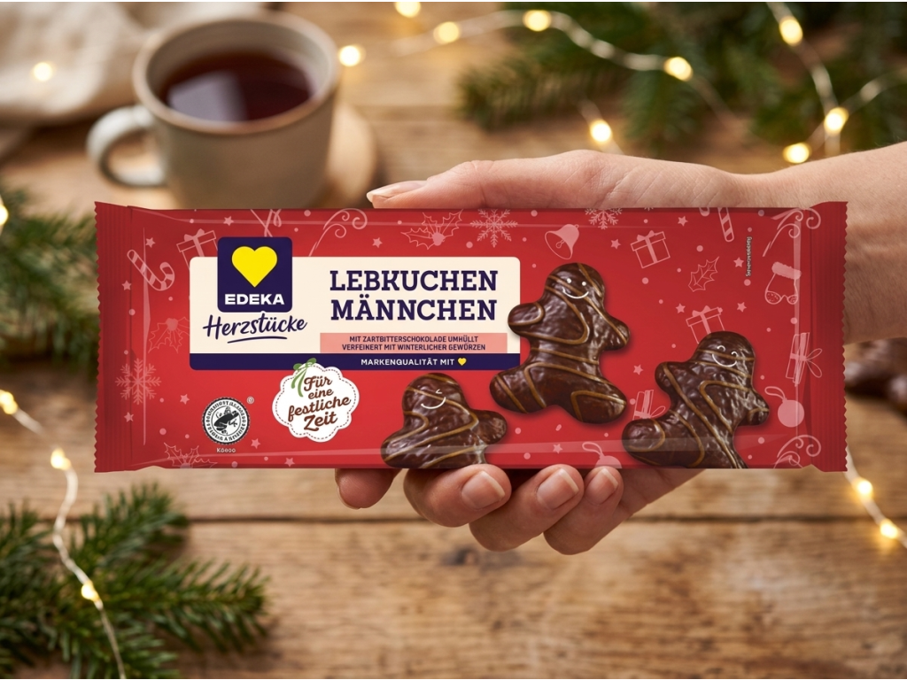 Edeka Herzstücke perníkoví panáčci v hořké čokoládě s mléčným dekorem 200 g držený v ruce